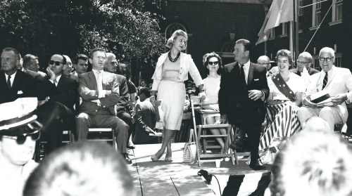 Sylvia W. Kauders standing on the aisle between Red Buttons&amp;nbsp;(left), John Wayne (right) seated beside the City of Philadelphia&amp;#39;s Miss Liberty Belle at Independence Hall